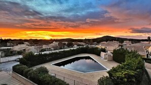 A square pool surrounded by buildings with a sunset in the background. - Studio with pool access in Cap d'Agde (Cap d'Agde)