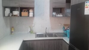 Una cocina con armarios de madera, un lavamanos doble y un refrigerador.