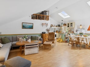 Un espacio habitable estilo loft con techo alto, comedor y cocina.