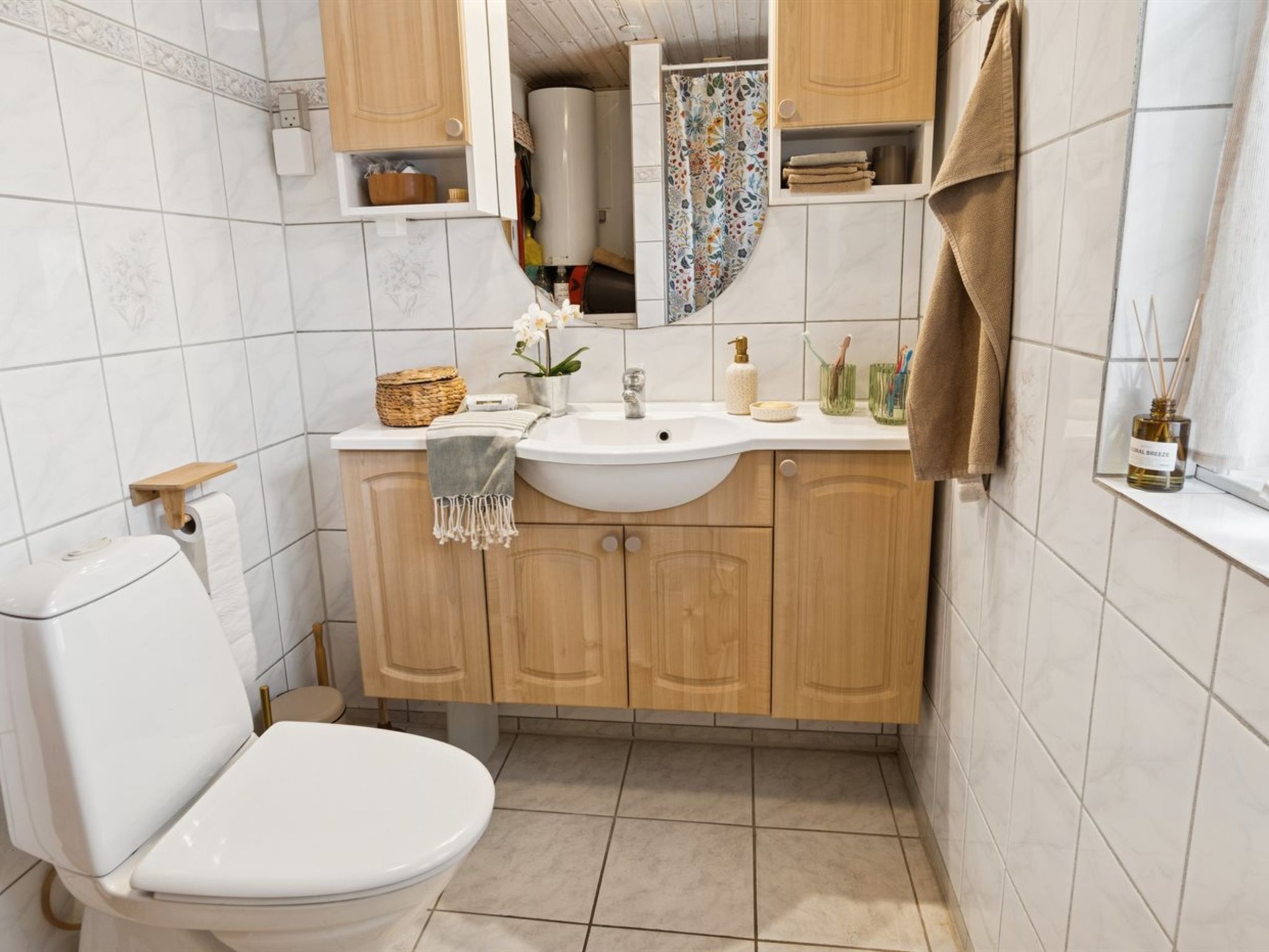 Une petite salle de bain comprenant des toilettes, un lavabo et des meubles en bois.