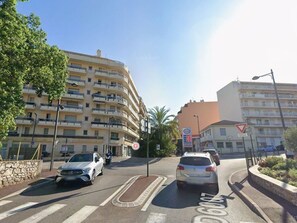 A multi-story building with balconies, a pedestrian crossing, and a car parked on the street. - Pleasant top floor 1BR with large terrace and private parking (Roquebrune-Cap-Martin)
