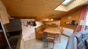 Une cuisine chaleureuse aux murs en bois, avec un coin repas.