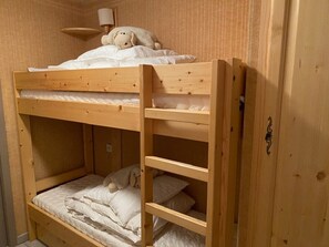 A bunk bed with a headboard, a bedside lamp, and a stuffed toy on the top bunk. - Family apartment near lifts, parking, south terrace (Châtel)