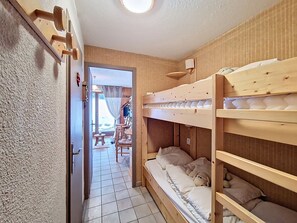 A compact room with a bunk bed, a small table, and chairs. - Family apartment near lifts, parking, south terrace (Châtel)