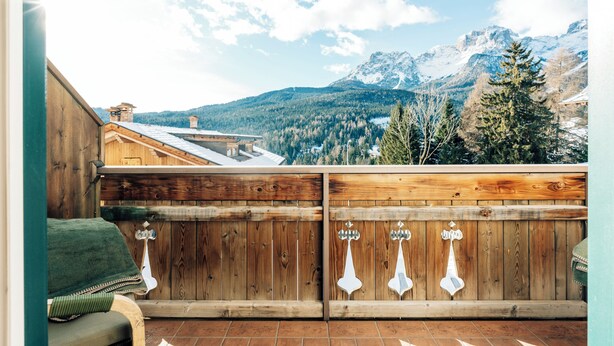 A wooden deck with a view of snow-capped mountains and a forested valley. - Appartment le Gemme Dolomites escape (Dosoledo)