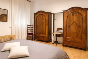 A bedroom with a large bed, two bedside tables, a chair, and two wardrobes. - Near the center of Trieste - Apartment for couples, families, and business travelers (Trieste)