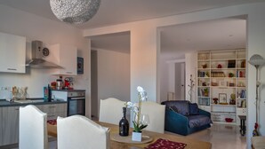 Ein moderner Wohnraum mit Essbereich, Küche und einer gemütlichen Sitzecke mit Bücherregal.