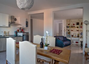 Ein moderner Wohnraum mit Essbereich, Küche und einer gemütlichen Sitzecke mit Bücherregal.