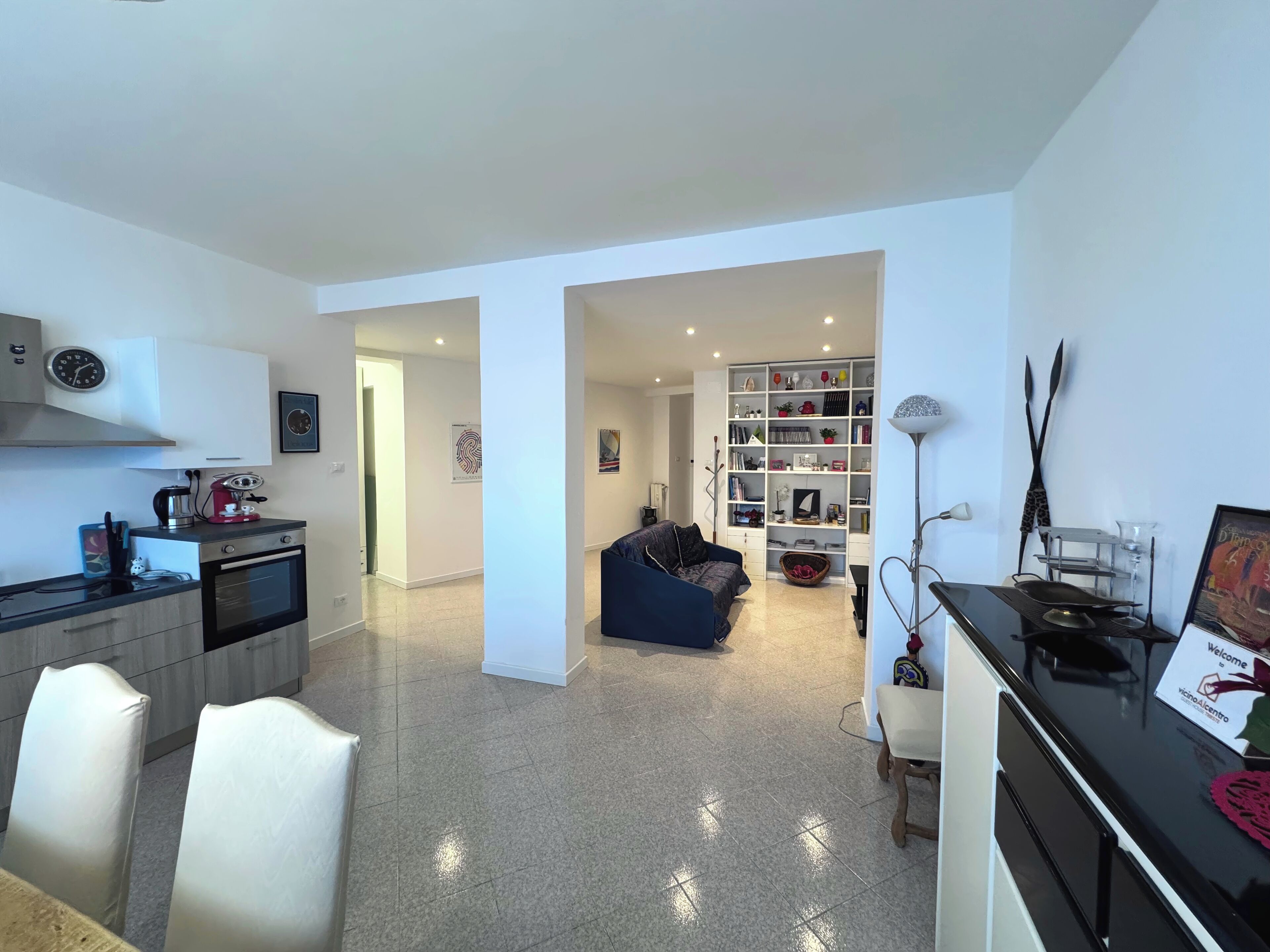 A modern living space with a kitchen, dining area, and a cozy seating area.