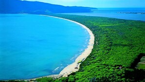 An aerial view of a coastal area with a beach and dense greenery. - Tenuta San Crescenzio (Toscana)