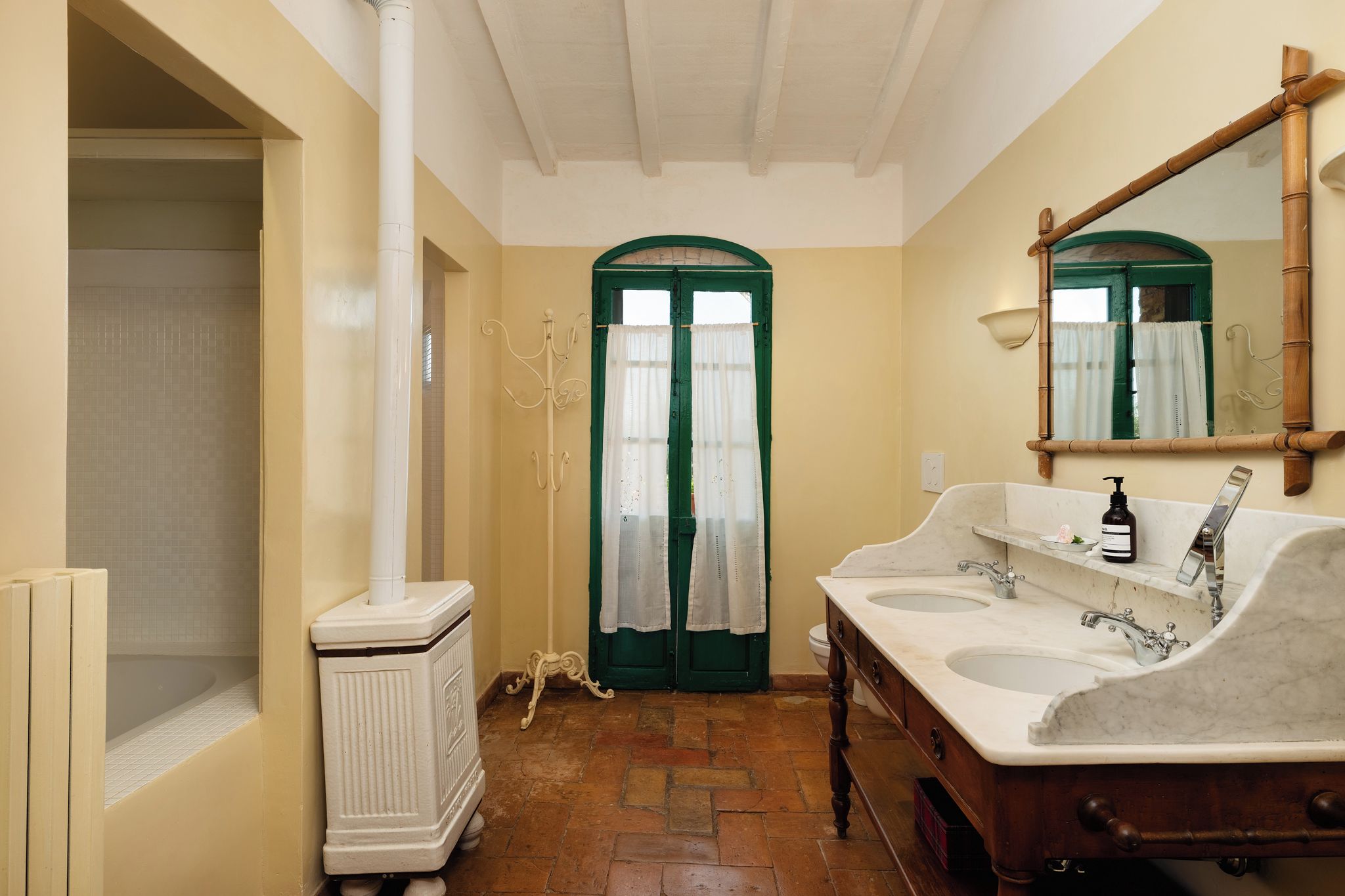 A bathroom with two sinks, a mirror, and a radiator.