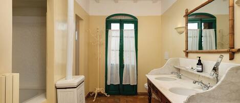 A bathroom with two sinks, a mirror, and a radiator.