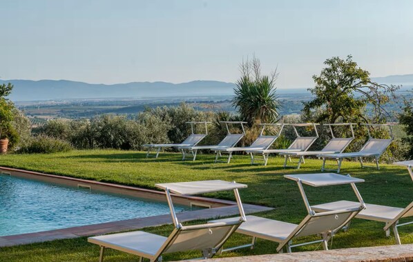 A poolside area with lounge chairs and a view of the countryside. - Tenuta San Crescenzio (Toscana)