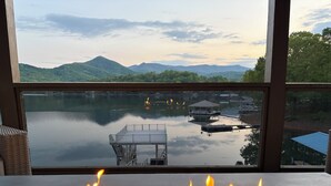 Ein Feuerplatz mit Blick auf einen See, eine Anlegestelle und Berge.