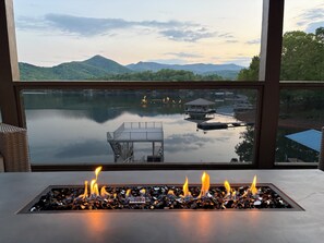 A fire feature with a view of a lake, dock, and mountains. - Still Waters at Lake Chatuge - Private Dock, Hot Tub, Kayaks, SUPs, &  Game Room (Hiawassee)