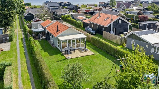 Un área residencial con casas, un patio con césped y vista al mar.