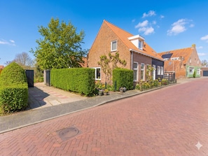 A residential street with brick houses, a clear sky, and a paved road. - Modern Holiday Home in Vrouwenpolder (Koudekerke)