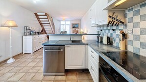 A modern kitchen with a central island, stainless steel appliances, and a tiled backsplash. - Sanoubott by Interhome (La Bernerie-en Retz)