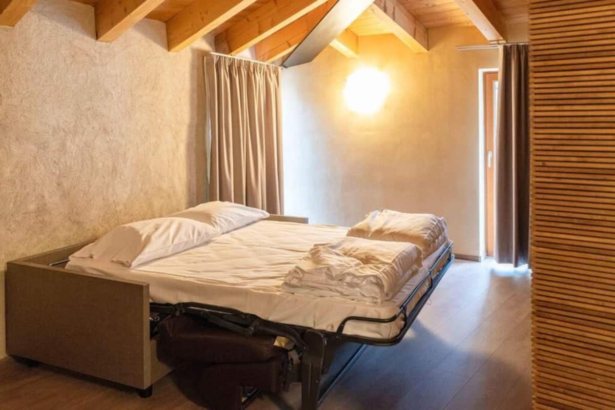 Ein Schlafzimmer mit einem Bett, einem Nachttisch und einem Fenster mit Vorhängen.
