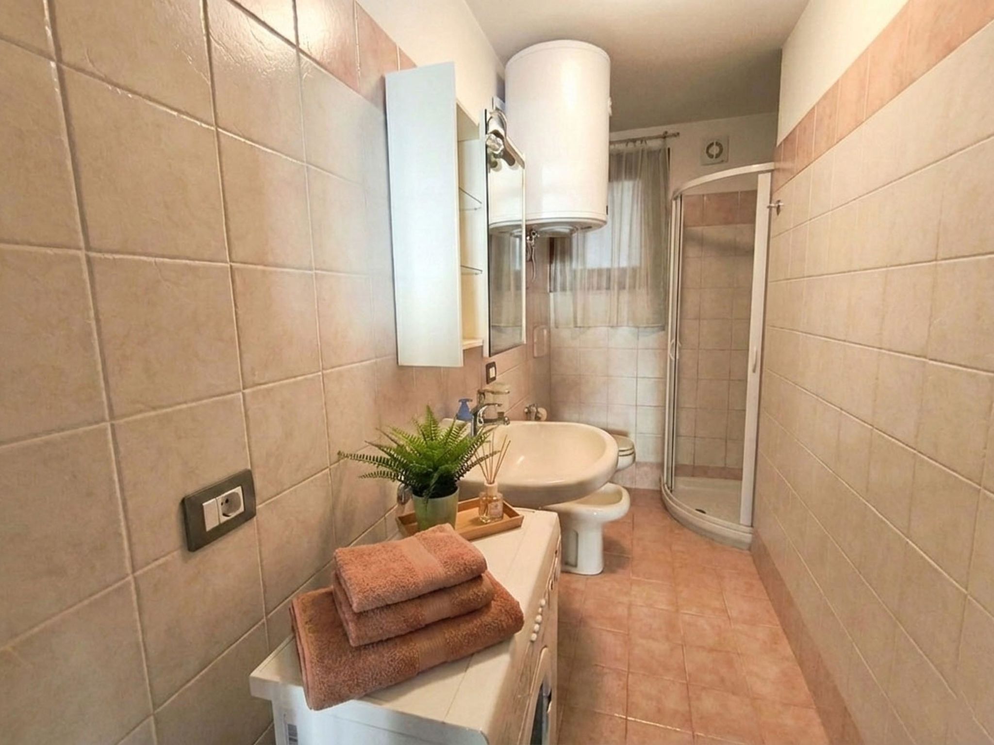 A bathroom with a sink, mirror, and shower.