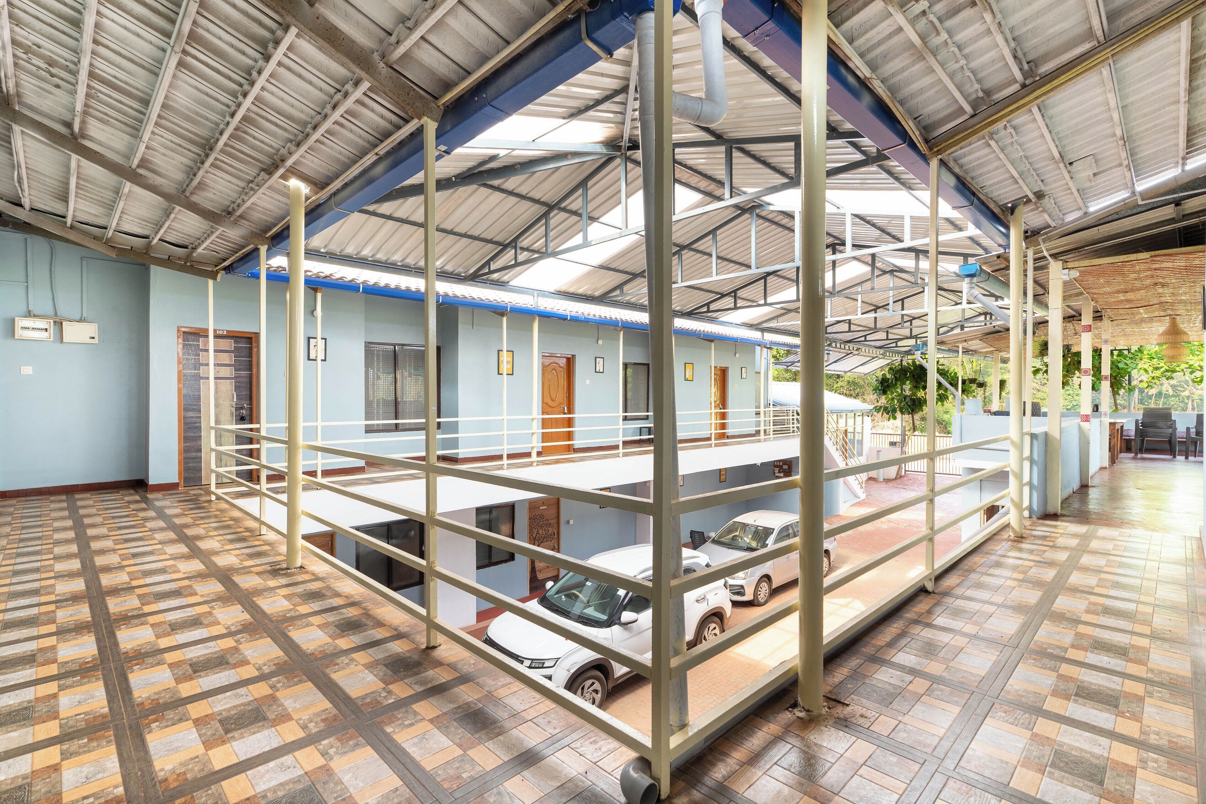 Un parking à plusieurs niveaux, doté d’une structure métallique, de revêtements de sol en carrelage et d’une zone couverte offrant une vue sur l’extérieur.