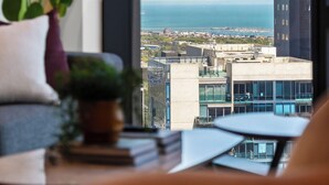 A view from a window overlooking a cityscape with modern buildings and a body of water. - Queensbridge Luxe Living Next to Crown on the River. Pool • Gym • Sauna Steam (Southbank)