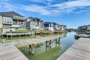 A waterfront residential area with houses, a dock, and a calm water body. - Selah on Lake Conroe: Lakefront, Boat Dock, Views (Willis)
