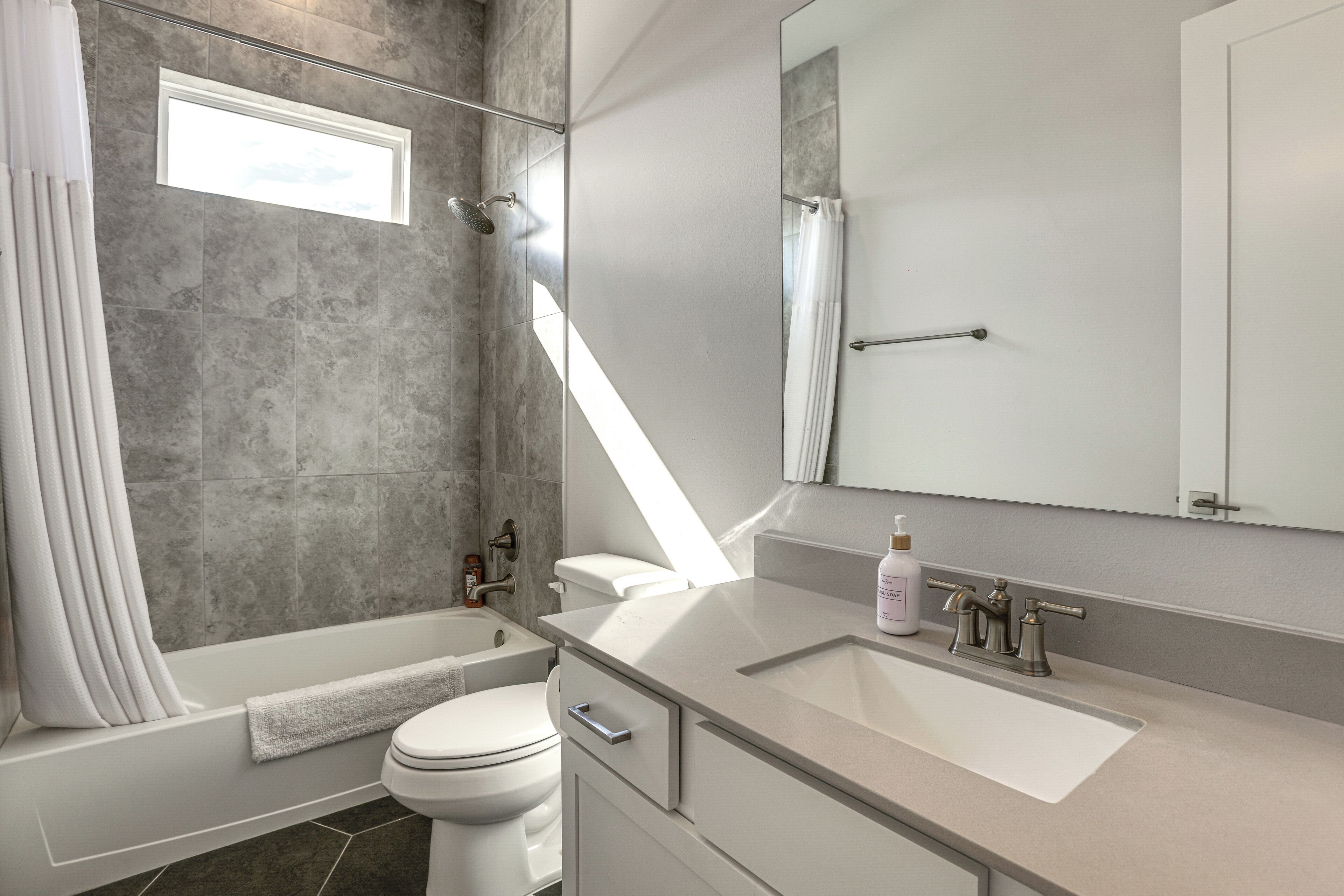 Un baño moderno con bañera, inodoro y lavamanos.