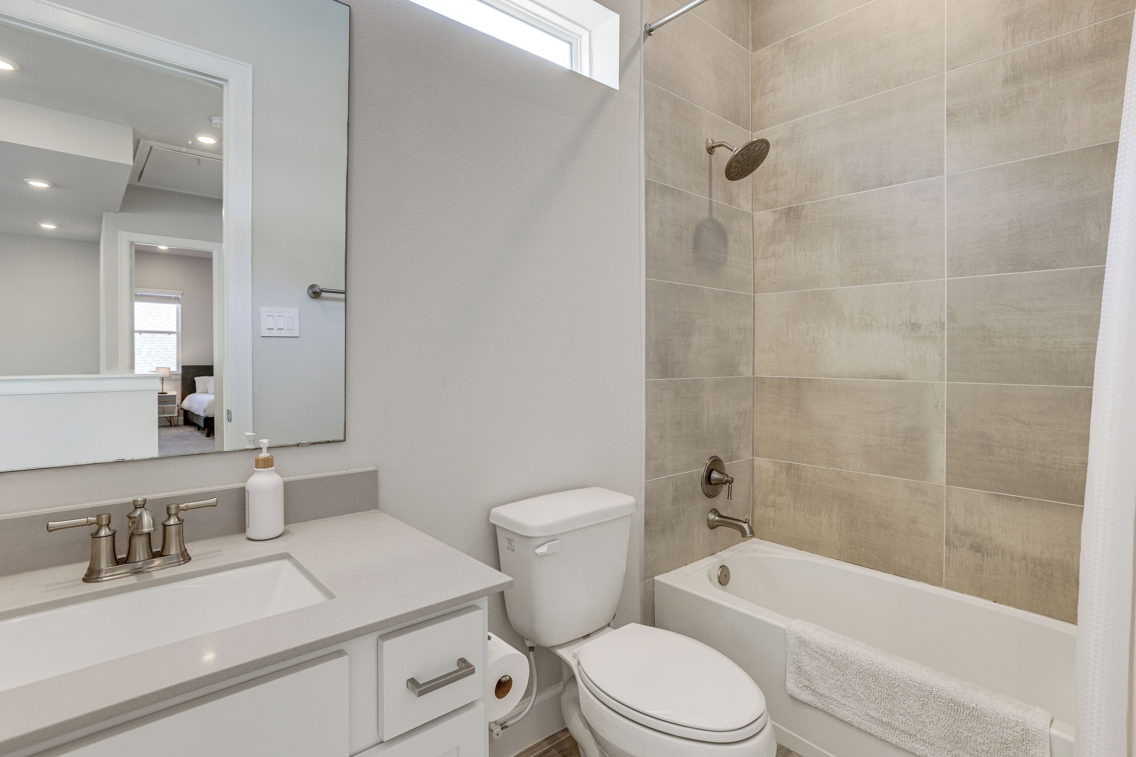 A modern bathroom with a white sink, toilet, and bathtub.