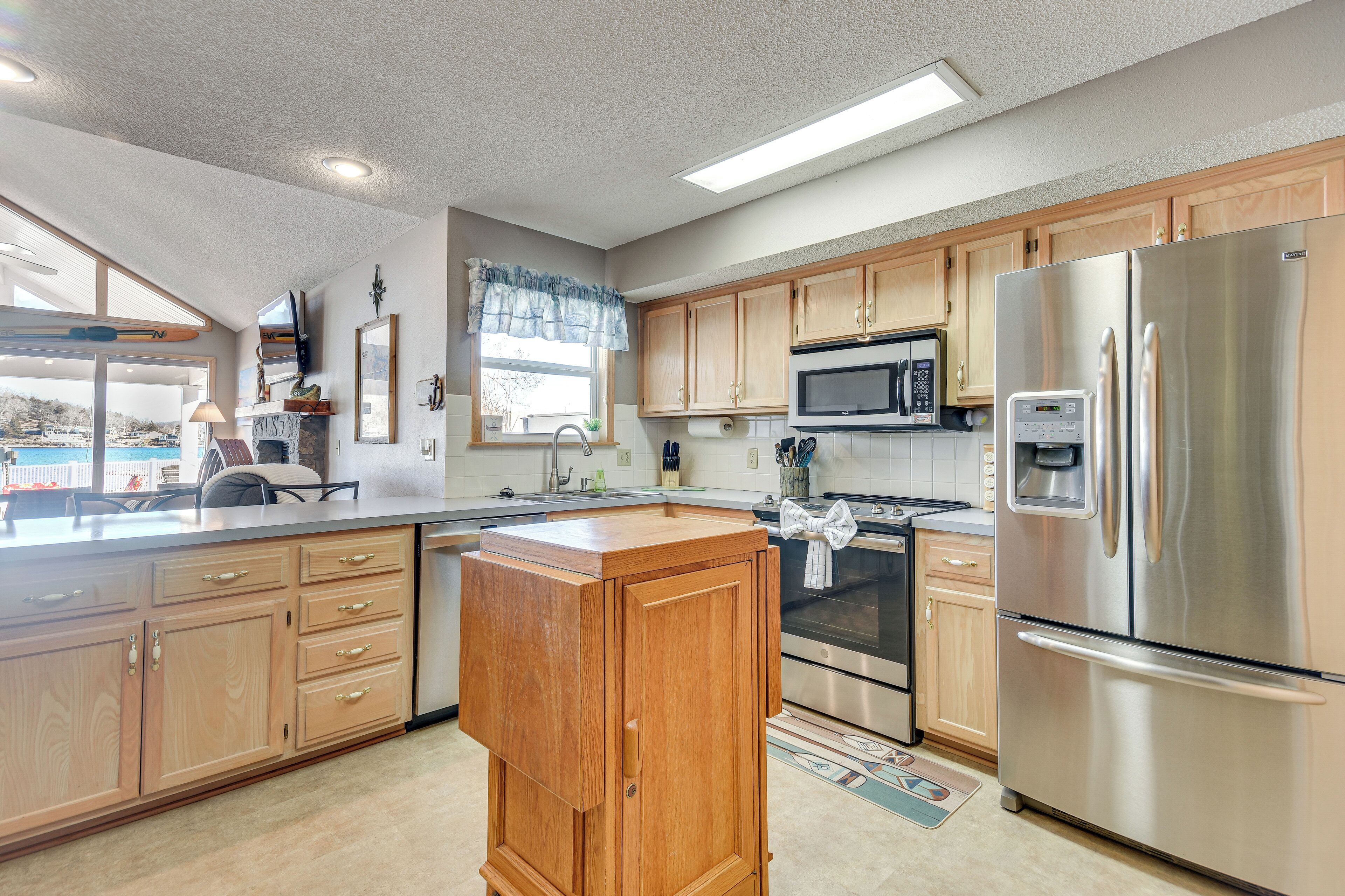A modern kitchen with wooden cabinets, stainless steel appliances, and a large island.