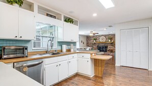 A modern kitchen with white cabinets, a built-in oven, and a dishwasher. - 5 Mi to Silver Springs State Pk: Gem w/ Game Room! (Ocala)
