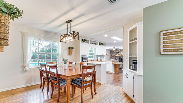 A modern kitchen with white cabinets, a central island, and a hanging plant. - 5 Mi to Silver Springs State Pk: Gem w/ Game Room! (Ocala)