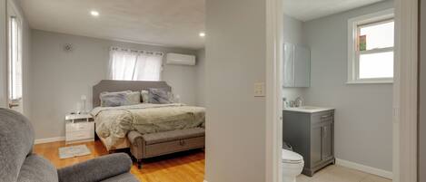 A bedroom with a bed, bedside tables, a dresser, and a window.