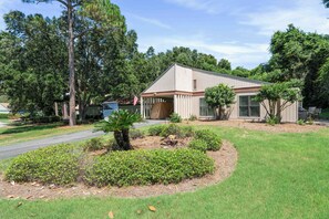 A single-story house with a front porch, surrounded by a well-maintained lawn and trees. - 546 Augusta Drive-4 Seat Golf Cart, Beach Access, Resort Pool, Golf Course! (Miramar Beach)