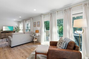 A modern living room with a sofa, a coffee table, a TV, and a lamp.