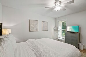 A bedroom with a bed, a ceiling fan, a TV, and artwork on the wall. - 546 Augusta Drive-4 Seat Golf Cart, Beach Access, Resort Pool, Golf Course! (Miramar Beach)