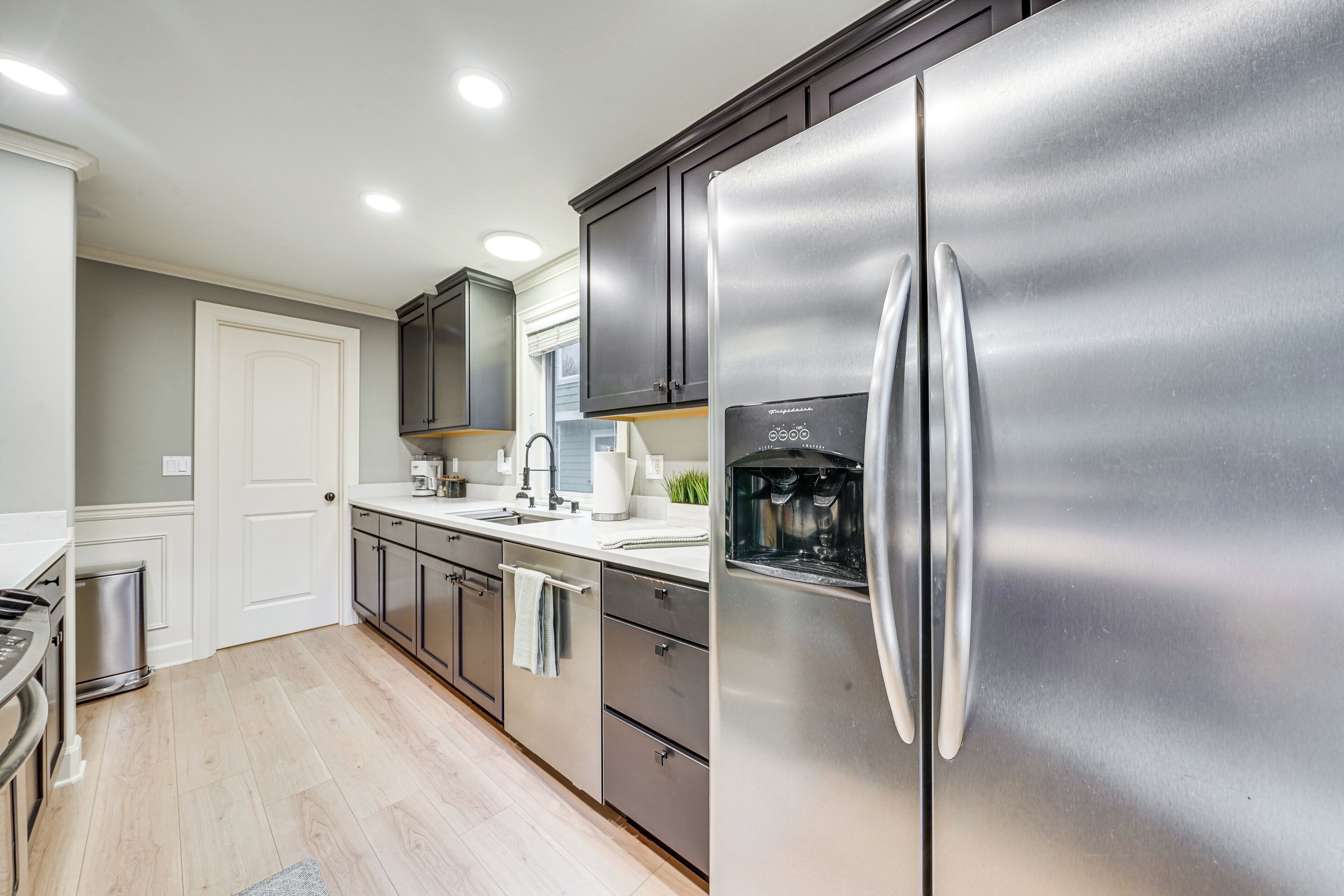 A modern kitchen with stainless steel appliances, a built-in oven, and a water dispenser.
