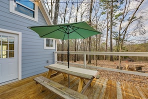 A wooden deck with a picnic table and a green umbrella. - Wooded Couple's Escape Near Trails & Lake Hawkins (Hawkins)