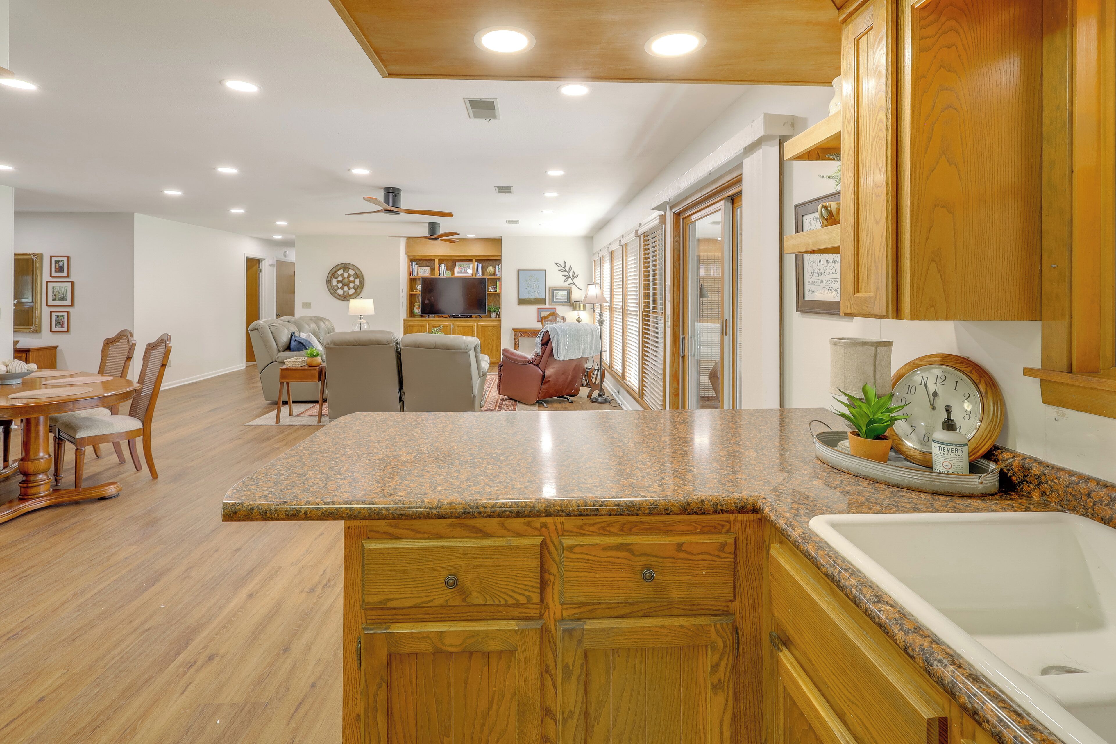 A spacious kitchen with wooden cabinets, a granite countertop, and a built-in sink.
