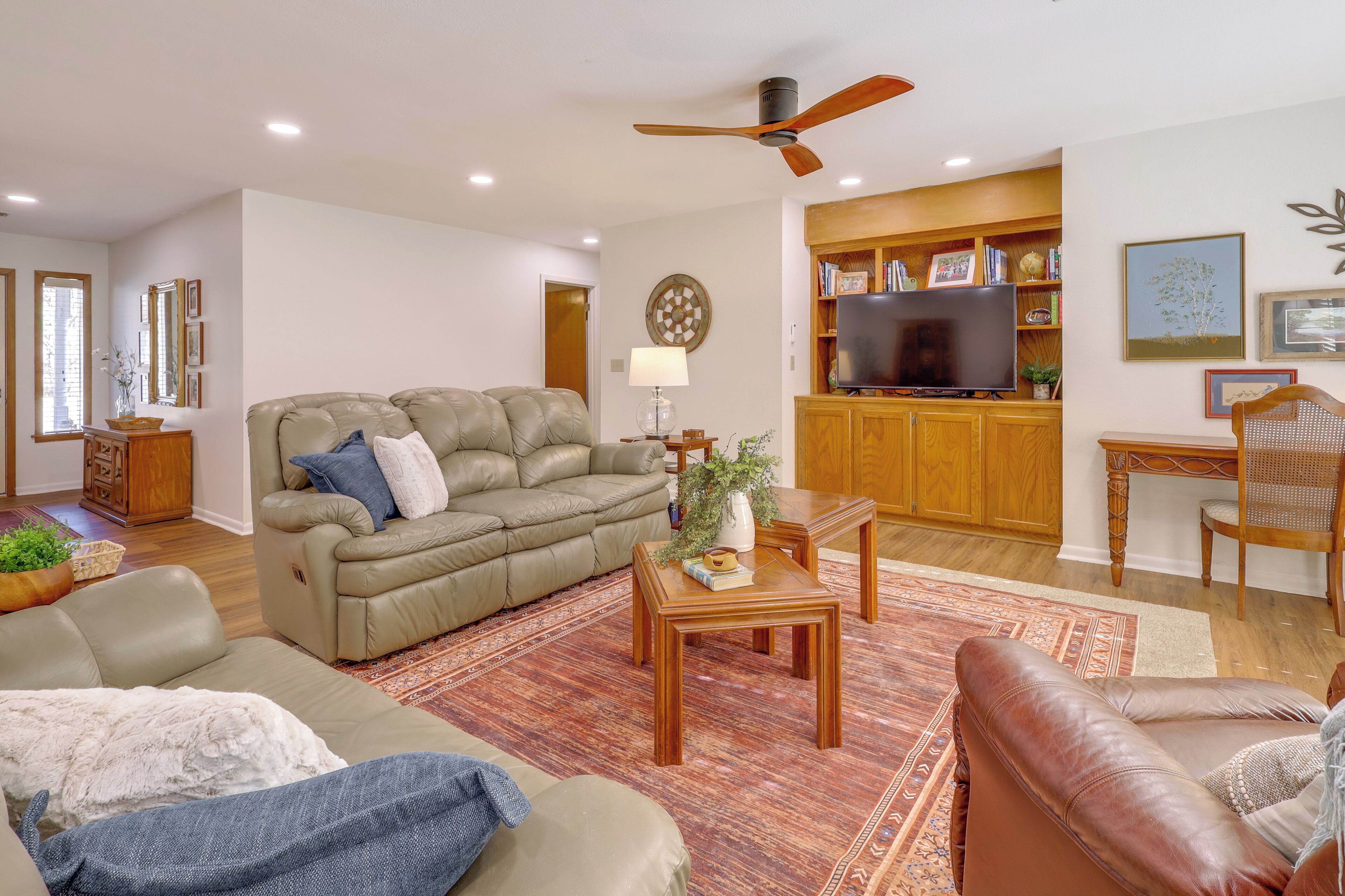 A living room with a sofa, coffee table, and a television on a wooden cabinet.