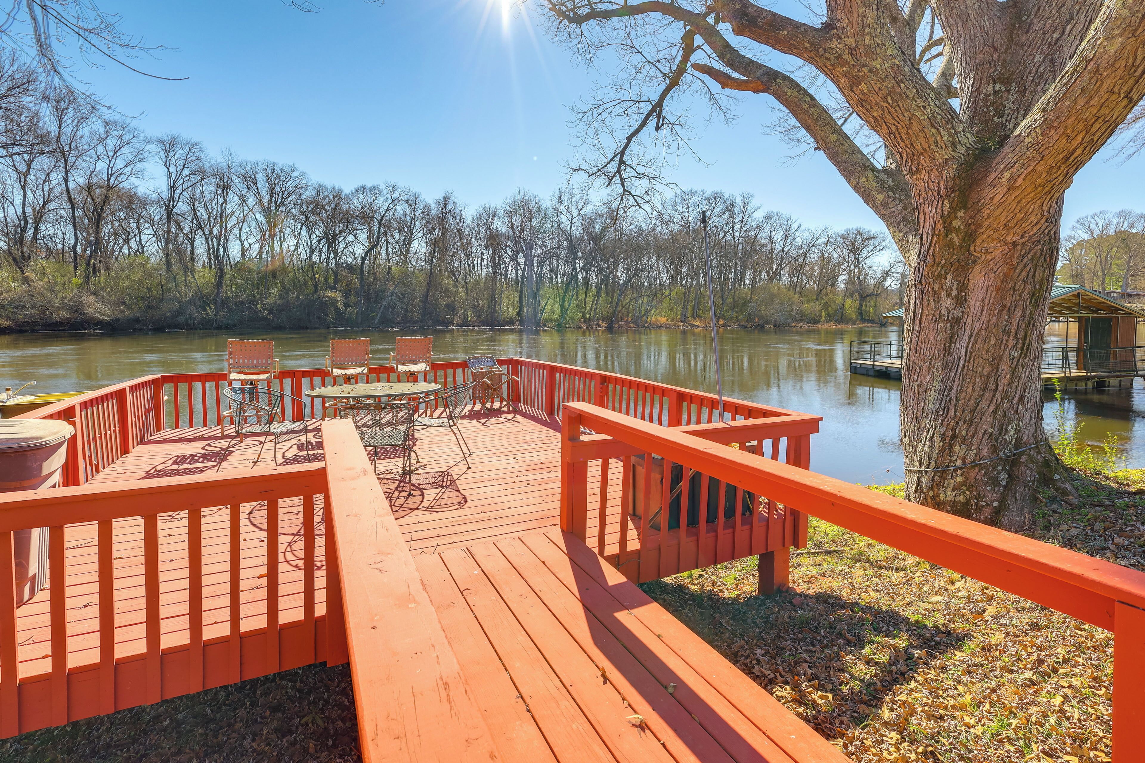 A wooden deck with outdoor furniture and a view of a lake.
