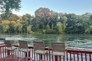 A deck with chairs overlooking a river, surrounded by trees. - Fish, Hike & Relax: Heber Springs Family Home (Heber Springs)