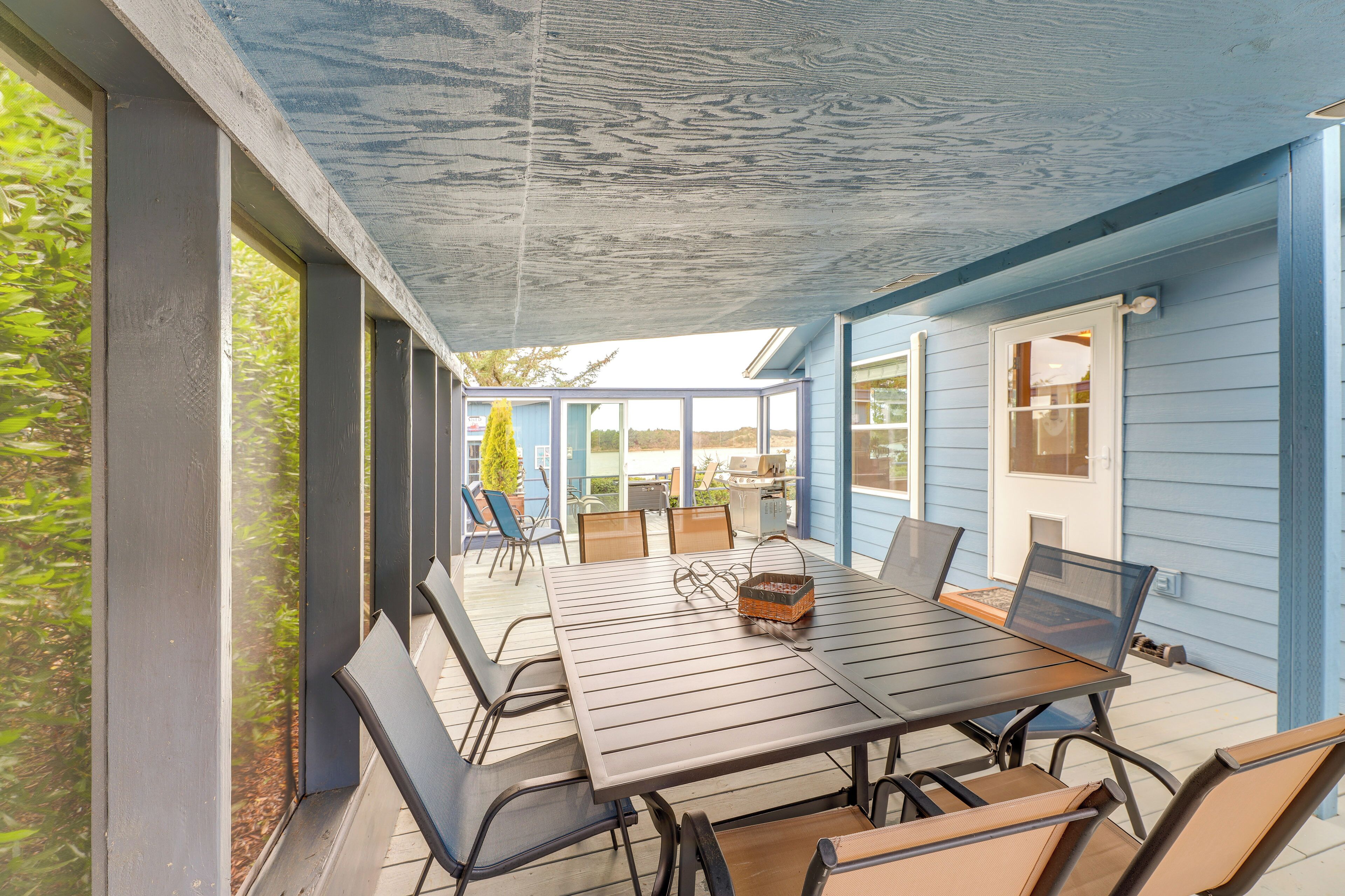 An outdoor patio with a table and chairs, a covered area, and a view of the surrounding landscape.
