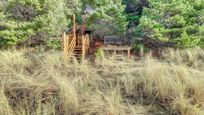 A wooden deck with a bench and a staircase leading to a platform. - Private Beach, Deck & Grill! Siuslaw River Getaway (Florence)