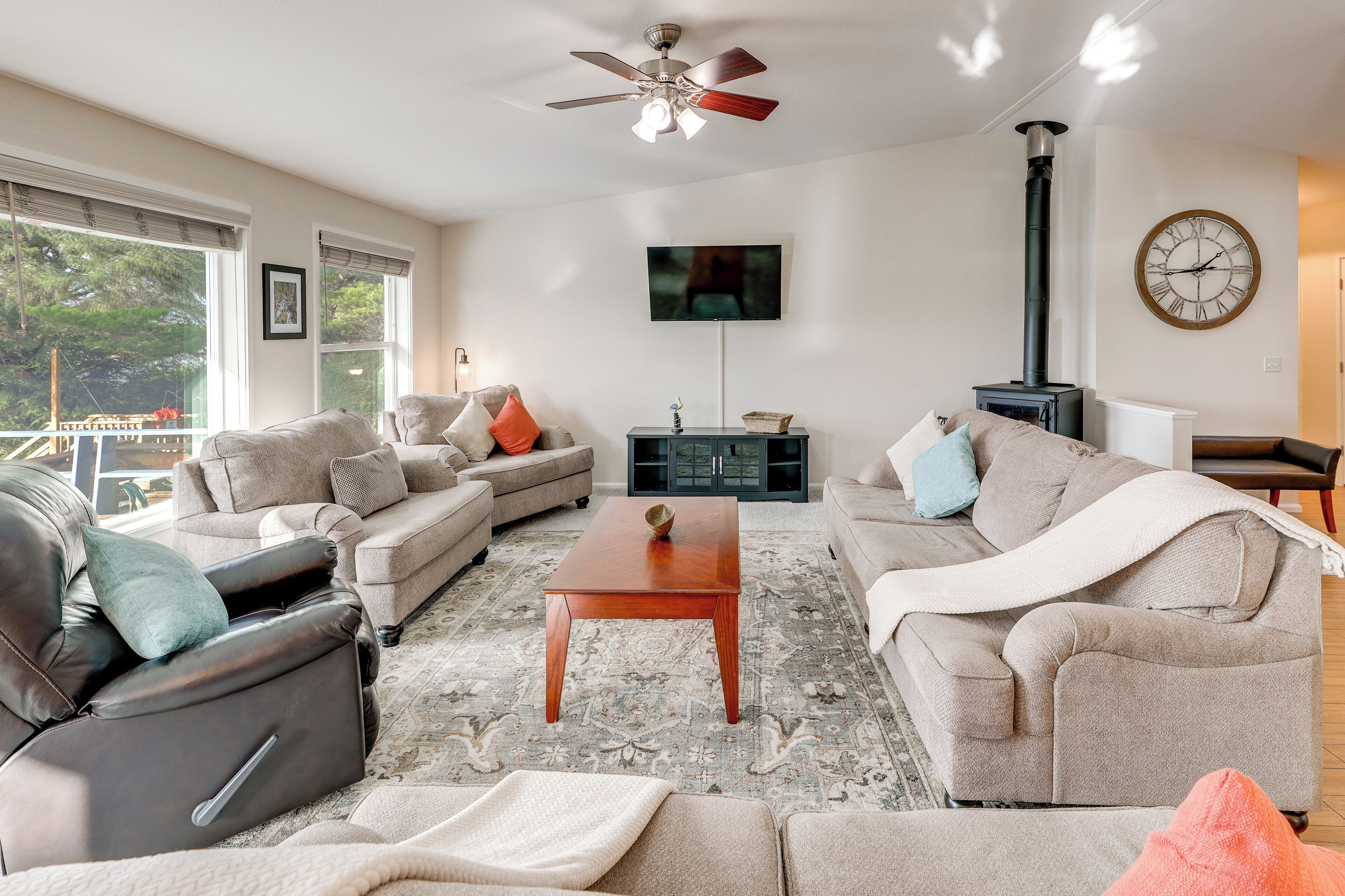 A living room with a sofa, a coffee table, a fireplace, and a TV mounted on the wall.