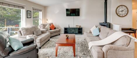 A living room with a sofa, a coffee table, a fireplace, and a TV mounted on the wall.