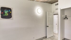 A room with a white door, a striped rug, and a wall-mounted light fixture. - 1 Mi to Main St Eats! Single-level Red Bluff Home (Red Bluff)