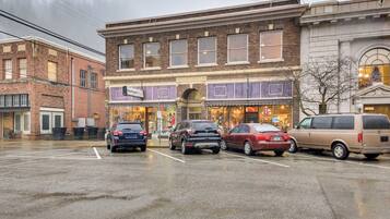 A street view with a row of parked cars in front of a building with a sign that reads "Presents."