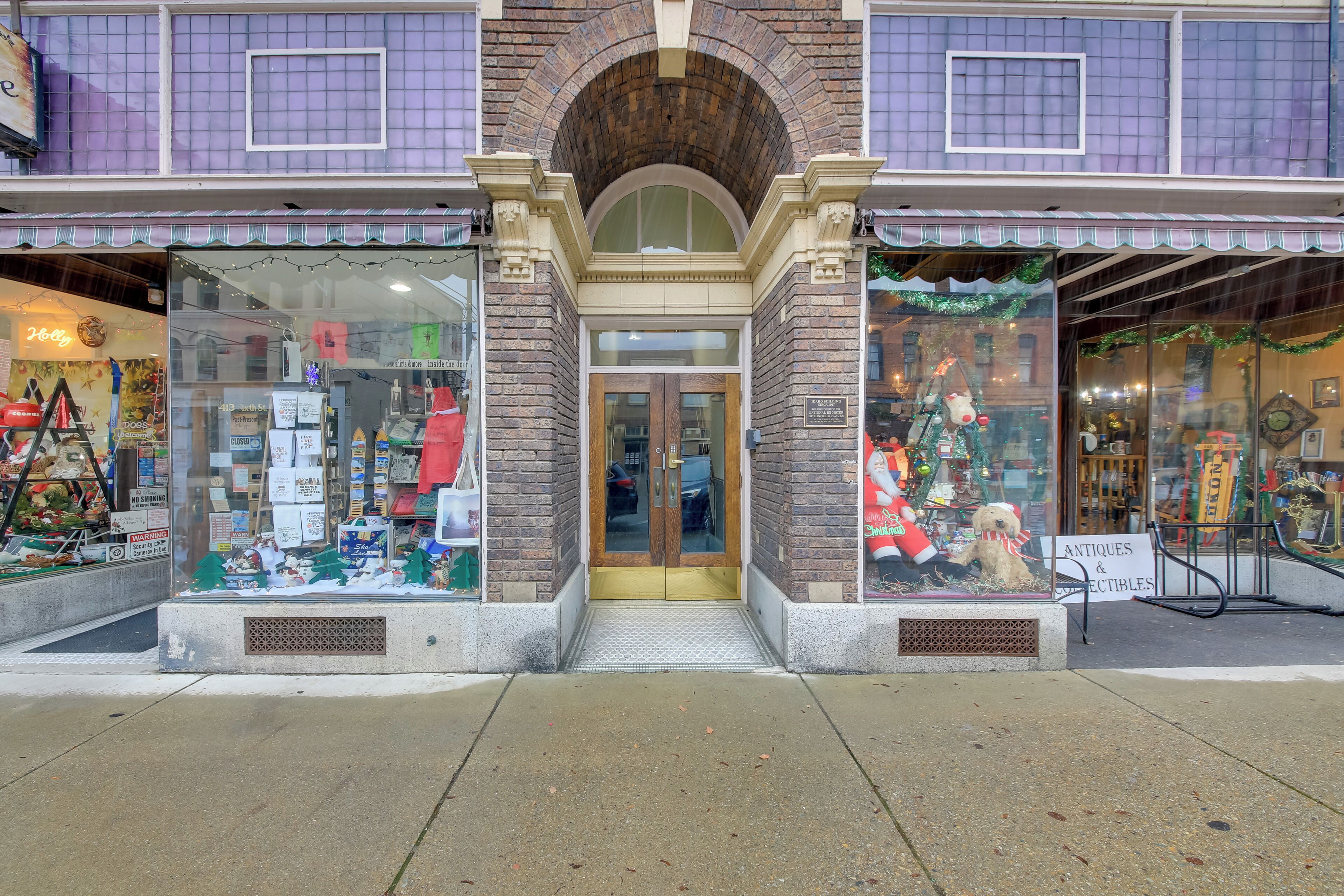 A storefront with a brick facade, large display windows, and a sign indicating it sells antiques and collectibles.