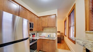 A kitchen with wooden cabinets, a stainless steel refrigerator, a microwave, and a sink. - Great for Skiing & Biking! Cozy Dtwn Wallace Condo (Wallace)